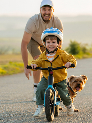 man teaching a boy to ride a bike