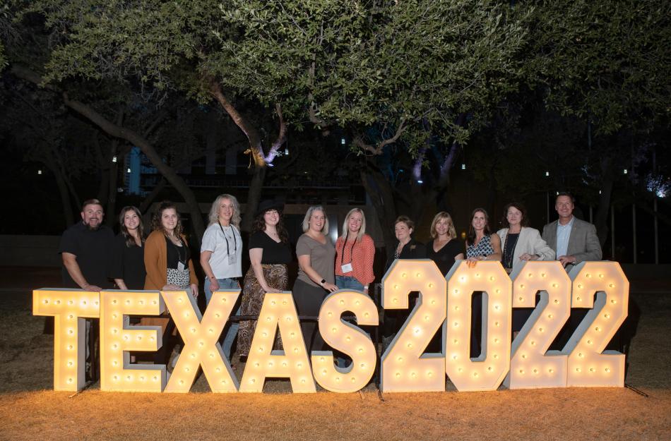 employees behind a lighted sign