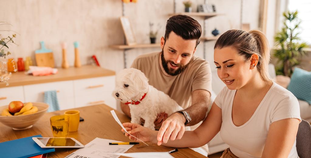 A guy and girl reviewing their bills in the kitchen.